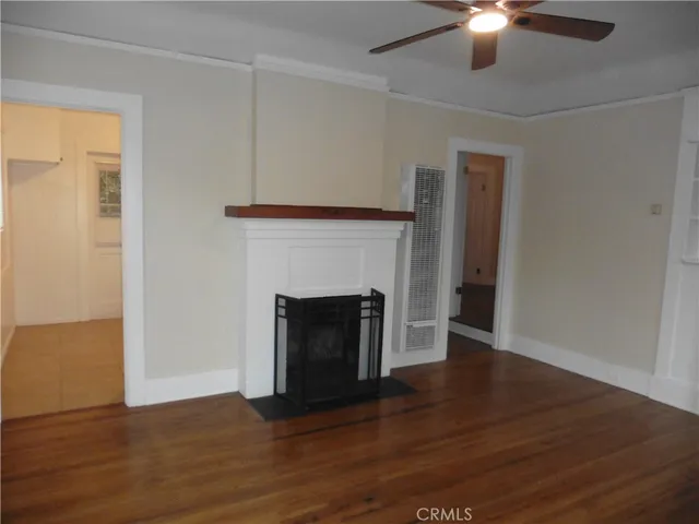 a view of a livingroom with a fireplace wooden floor and windows