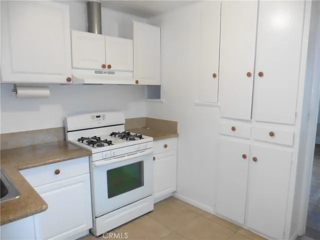 a white stove top oven sitting inside of a kitchen