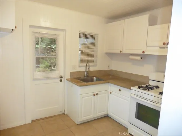 a kitchen with granite countertop white cabinets and white appliances