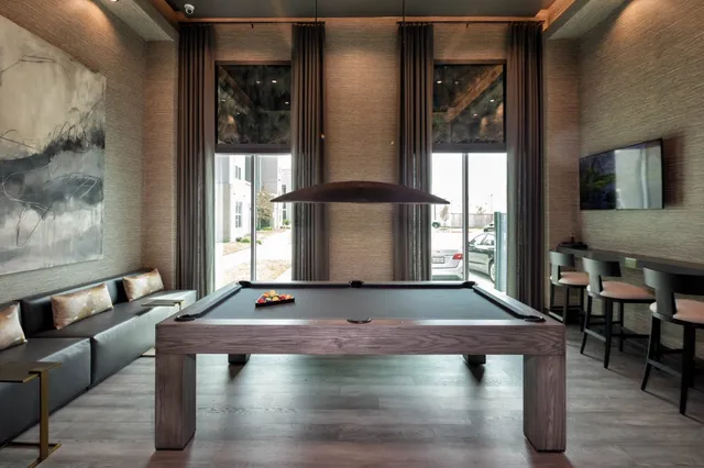 a room with pool table and two windows