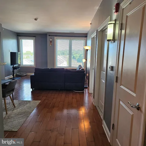 a living room with a couch wooden floor and a window
