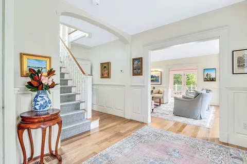 a living room with furniture a wooden floor and a potted plant