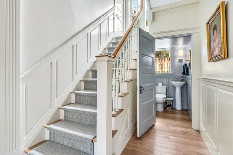 a view of entryway and hall with wooden floor
