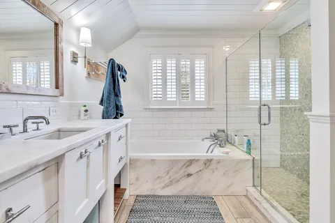 a bathroom with a granite countertop sink a mirror and a shower