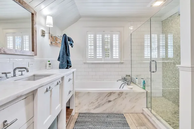 a bathroom with a granite countertop sink a mirror and a shower