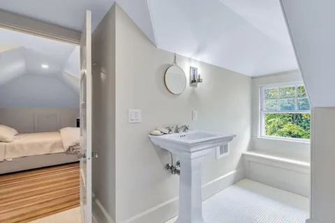 a bathroom with a sink a toilet a window and tub