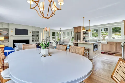 a dining room with furniture a large window and a fireplace