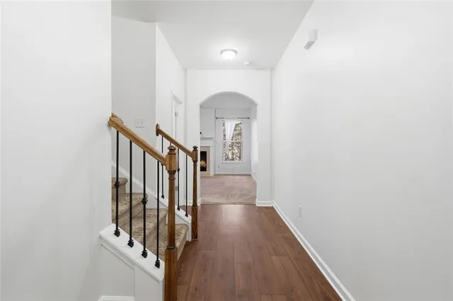 a view of a hallway with wooden floor and staircase