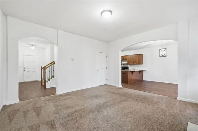 a view of empty room with a kitchen