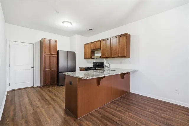 a kitchen with stainless steel appliances granite countertop a sink stove and refrigerator