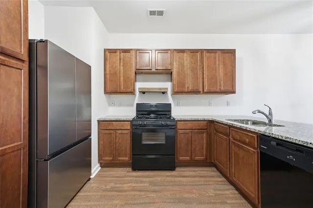 a kitchen with stainless steel appliances granite countertop a refrigerator and a stove