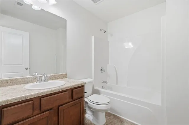 a bathroom with a sink toilet vanity and shower