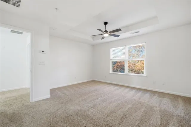 an empty room with windows and ceiling fan