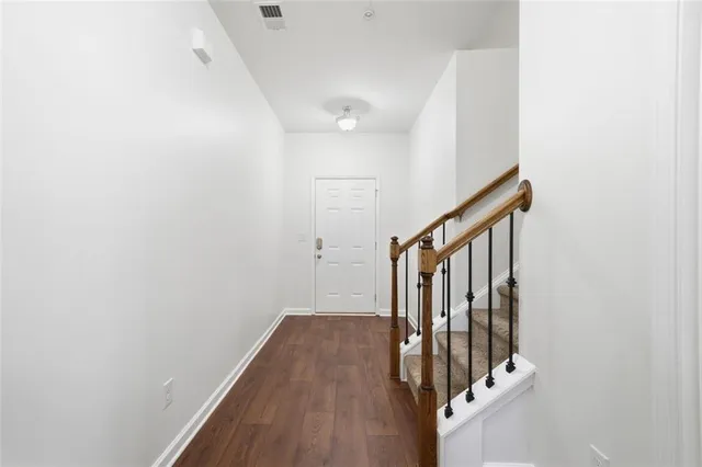 a view of a hallway with wooden floor and staircase