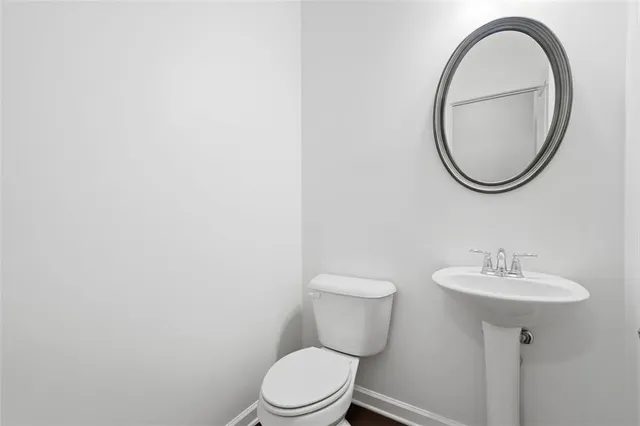 a bathroom with a toilet a sink and a mirror