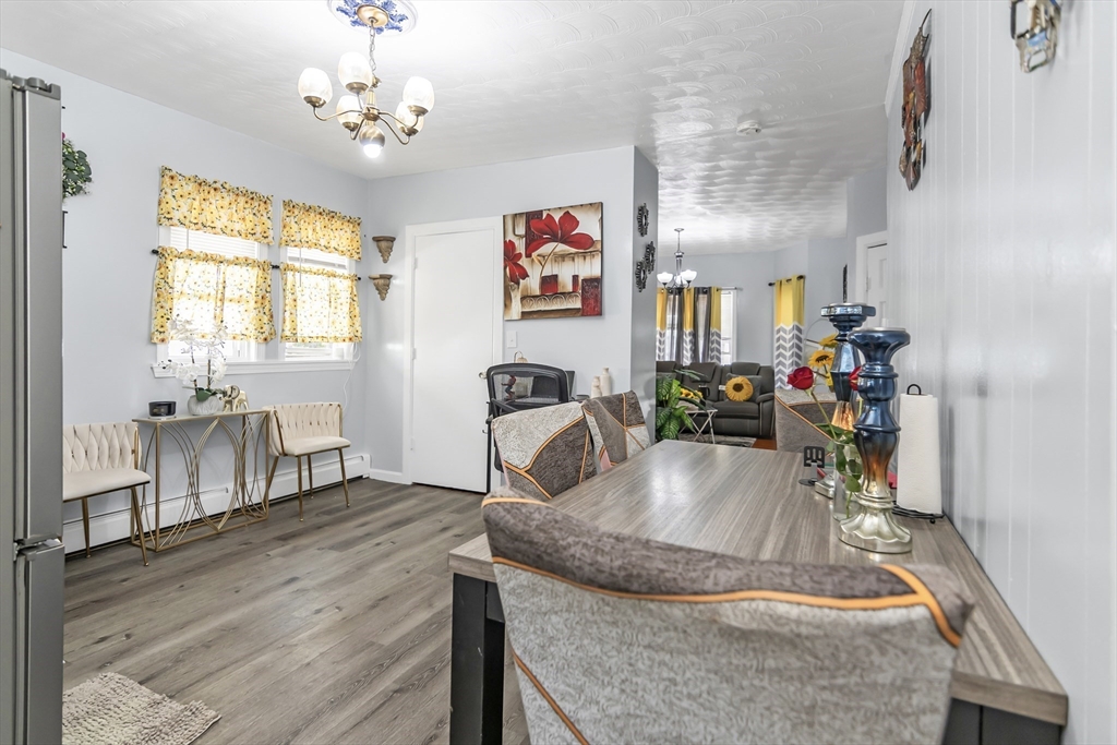 191 Farnham Street Lawrence, MA 01843 - Photo 9 of 31 a view of a dining room and livingroom with furniture wooden floor a chandelier