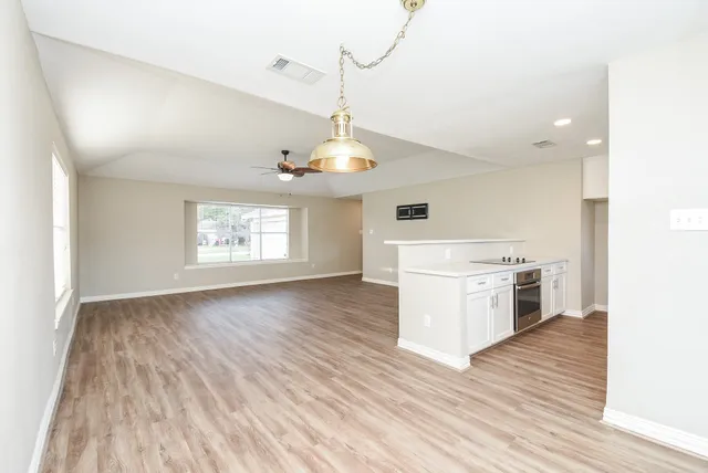 a open kitchen with a white cabinets and wooden floor