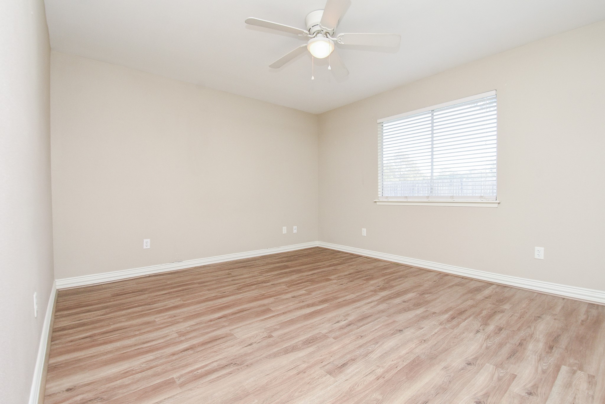 4606 Whispering Rock Lane Spring, TX 77388 - Photo 22 of 30 an empty room with wooden floor fan and windows