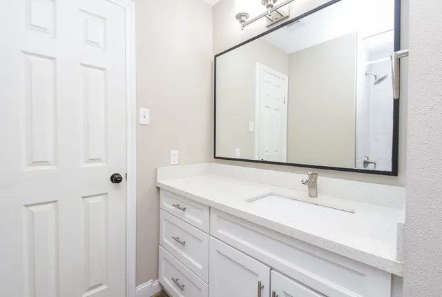 a bathroom with a granite countertop sink toilet and shower