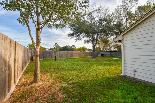 a view of yard with tree and wooden fence