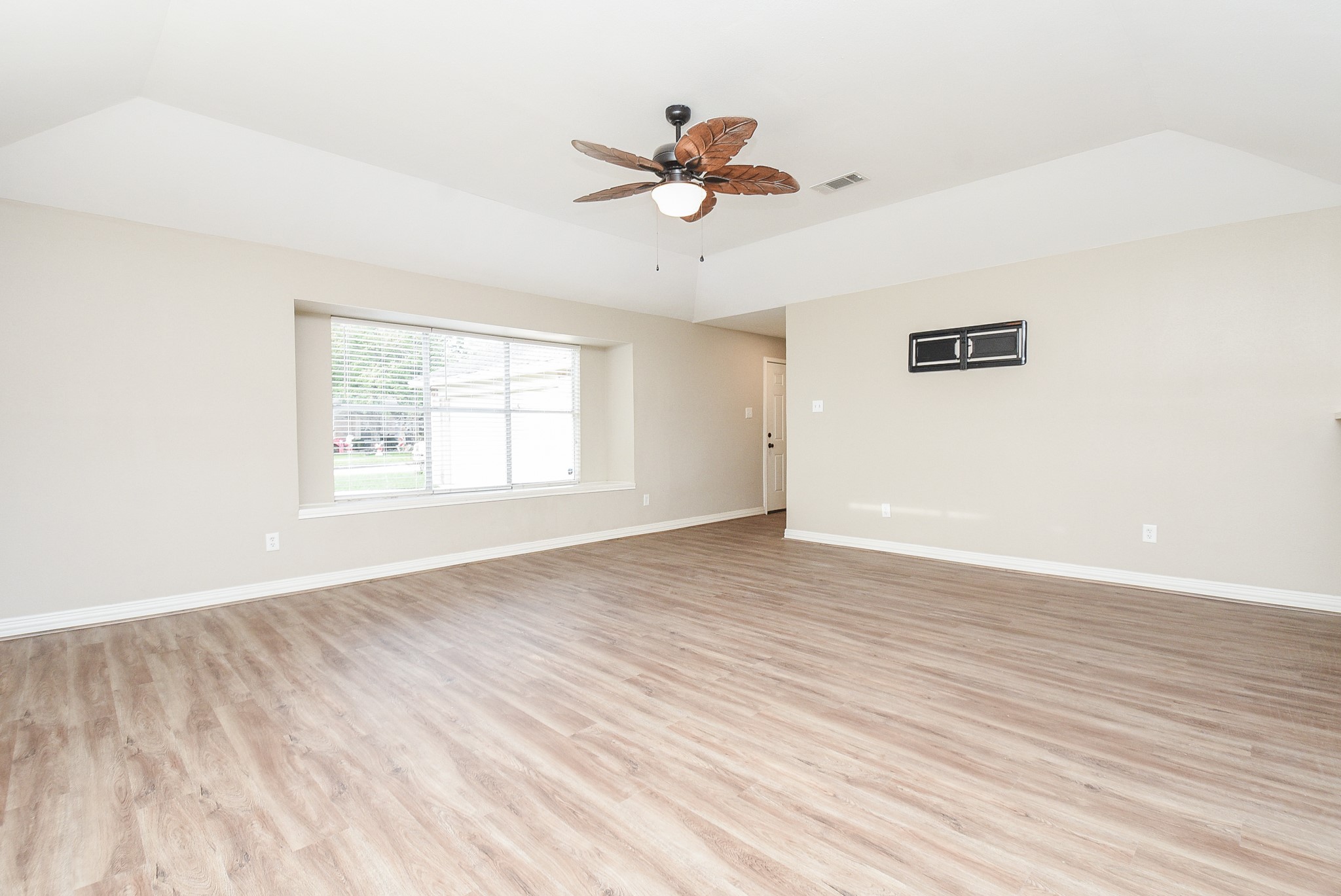 4606 Whispering Rock Lane Spring, TX 77388 - Photo 3 of 30 an empty room with wooden floor chandelier fan and windows