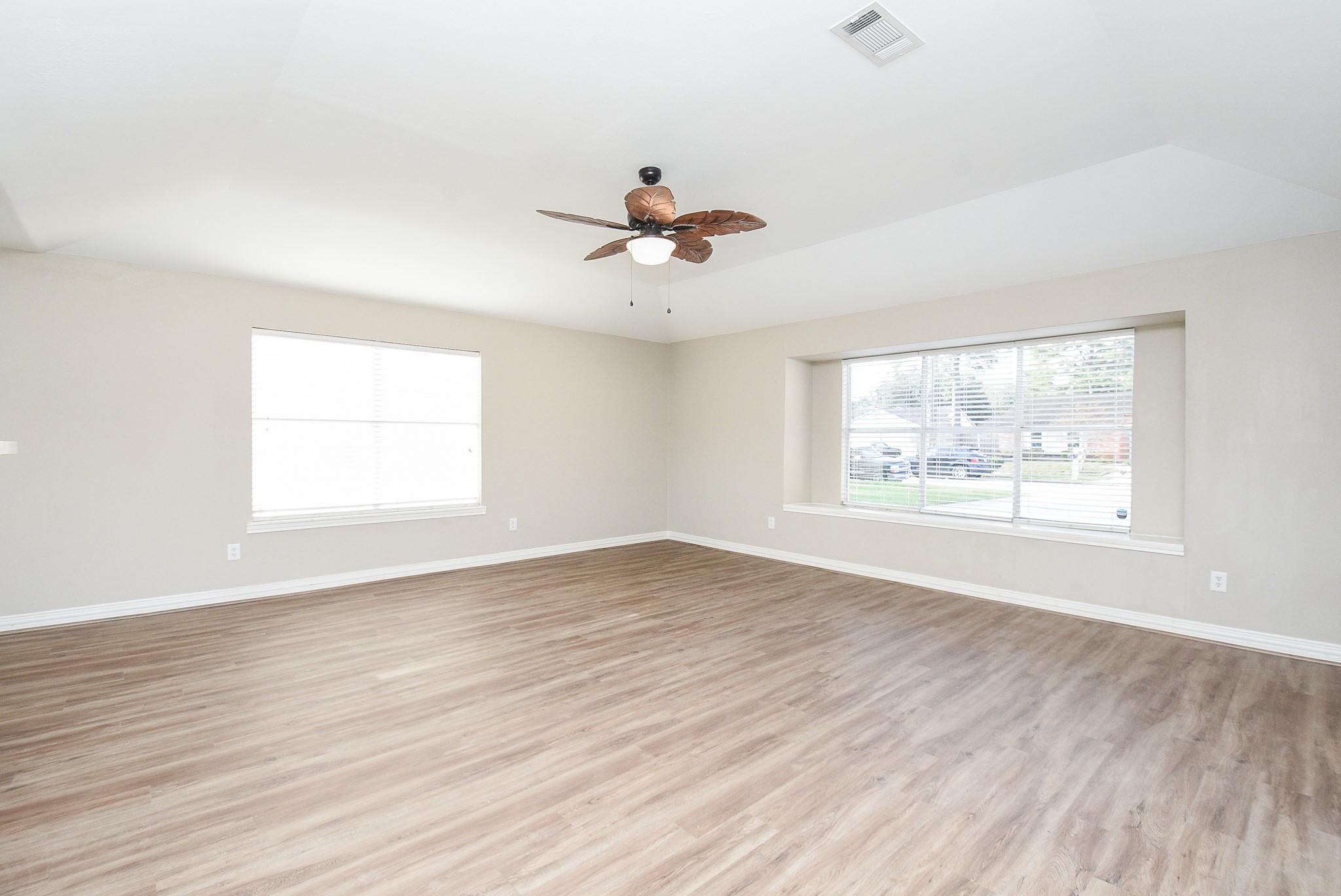 4606 Whispering Rock Lane Spring, TX 77388 - Photo 5 of 30 an empty room with wooden floor chandelier fan and windows