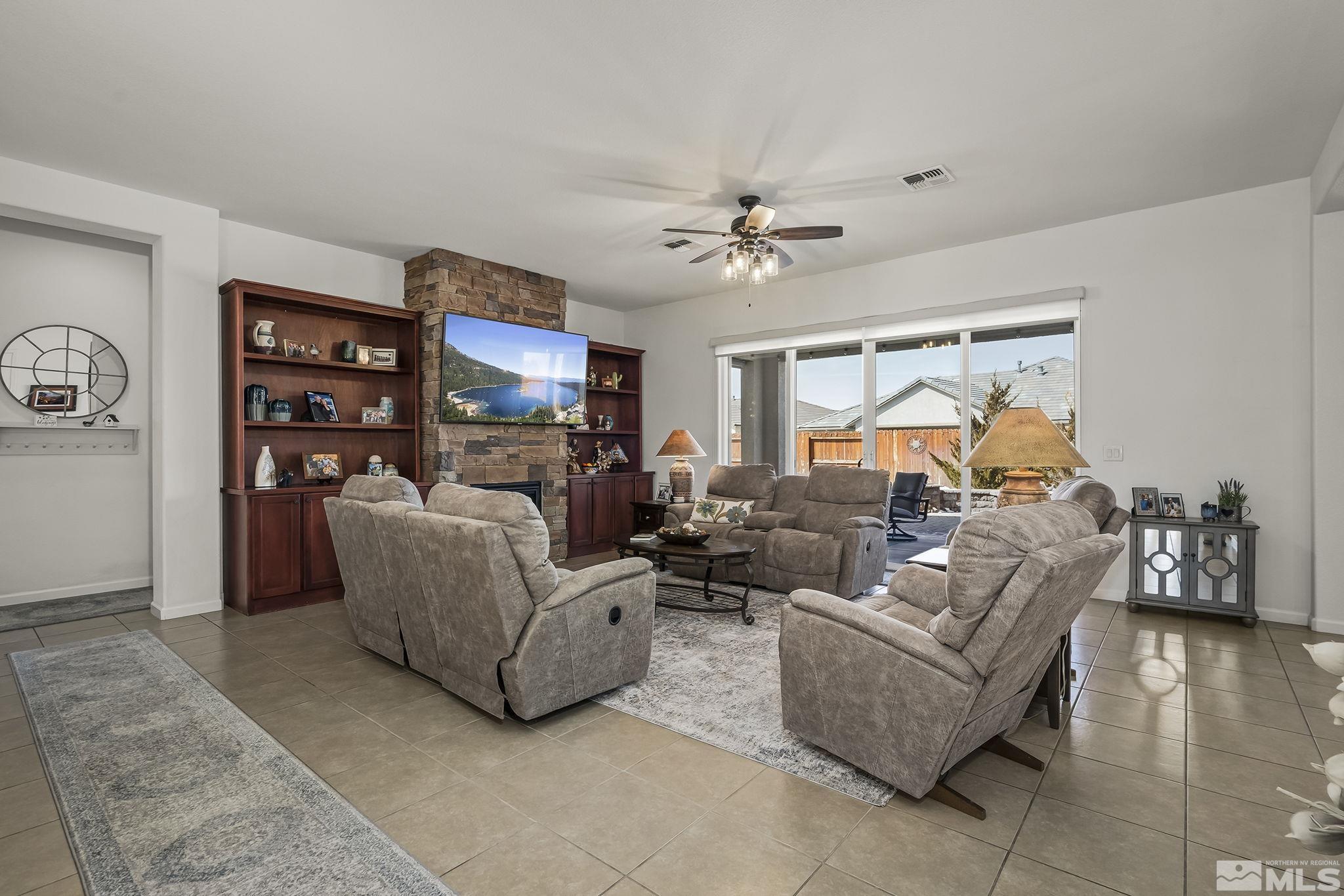 2215 Trakehner Lane Reno, NV 89521 - Photo 3 of 23 a living room with furniture a fireplace and a flat screen tv