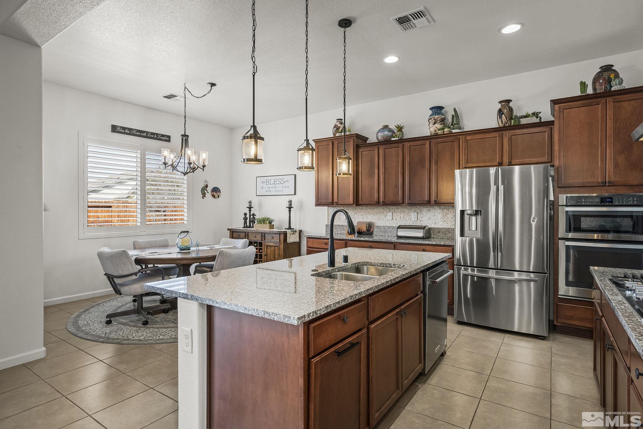 2215 Trakehner Lane Reno, NV 89521 - Photo 7 of 23 a kitchen with stainless steel appliances granite countertop a sink a stove and a refrigerator