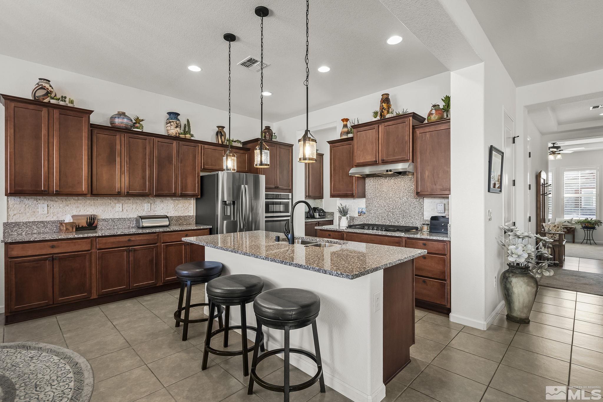 2215 Trakehner Lane Reno, NV 89521 - Photo 8 of 23 a kitchen with stainless steel appliances granite countertop sink stove and cabinets