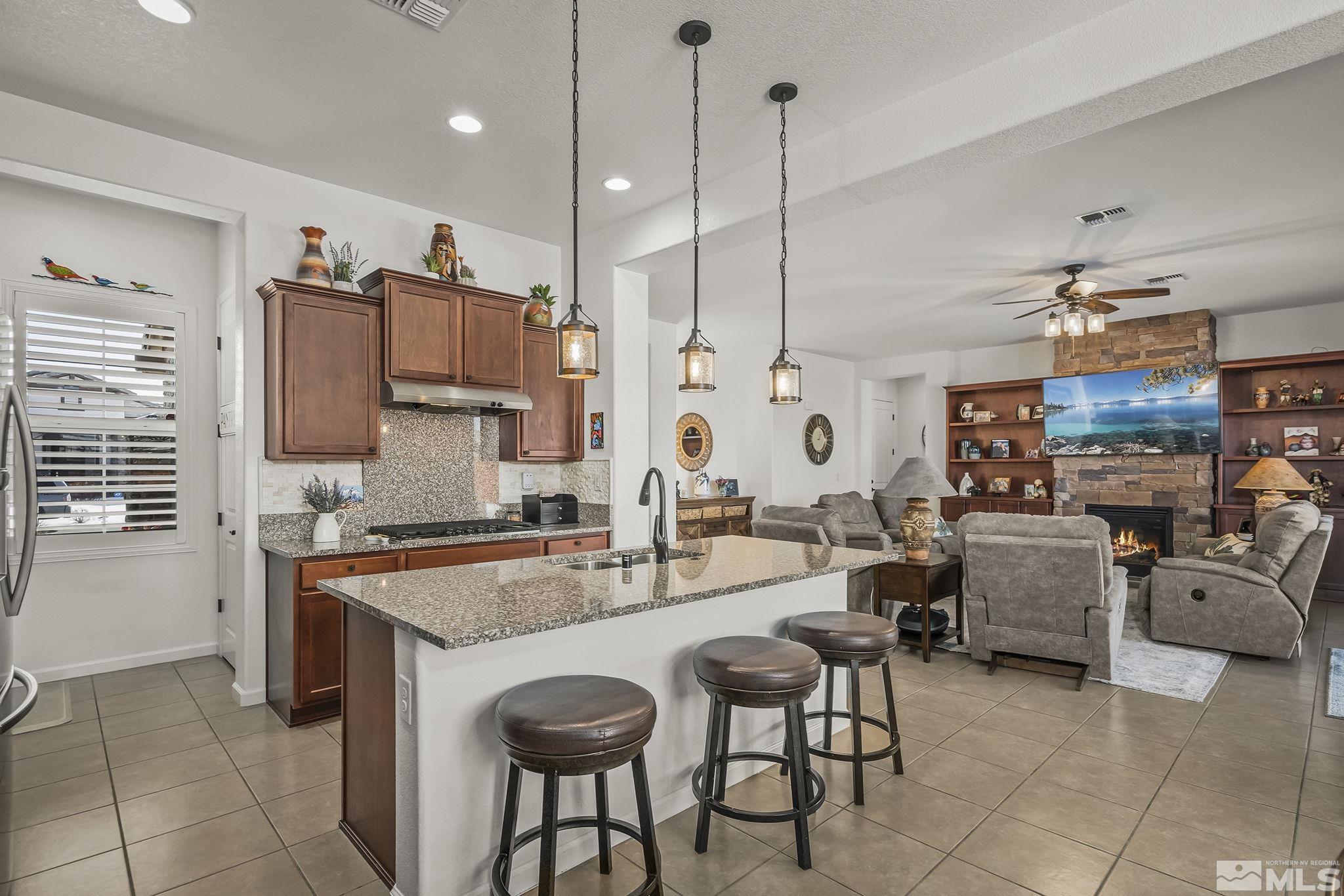 2215 Trakehner Lane Reno, NV 89521 - Photo 9 of 23 a kitchen with sink a stove and chairs