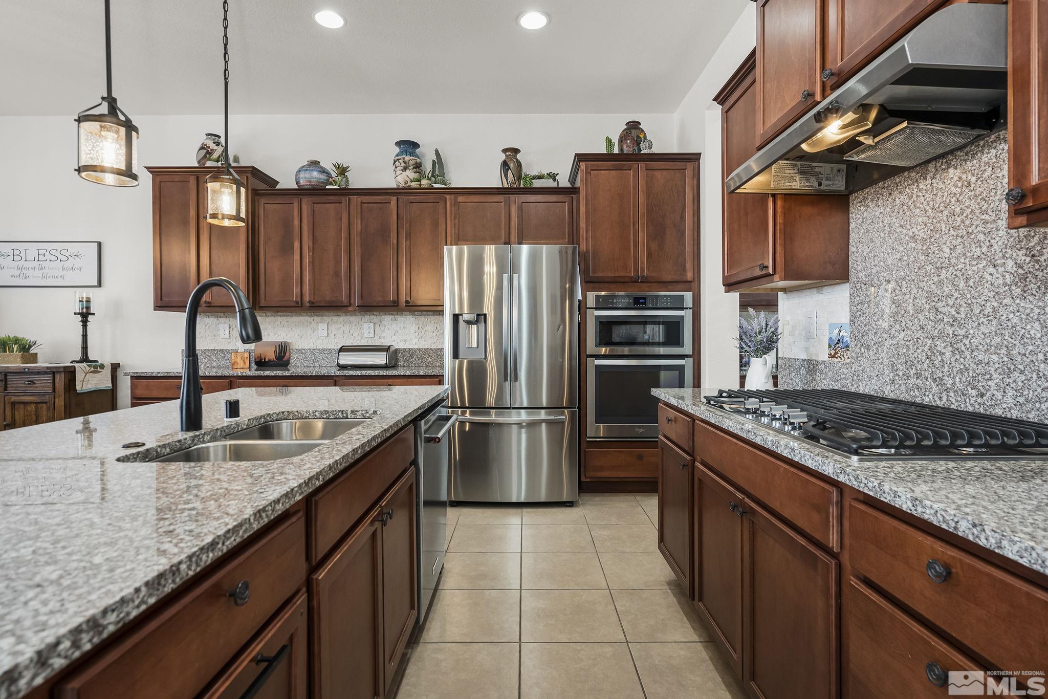 2215 Trakehner Lane Reno, NV 89521 - Photo 10 of 23 a kitchen with stainless steel appliances granite countertop a sink stove and refrigerator