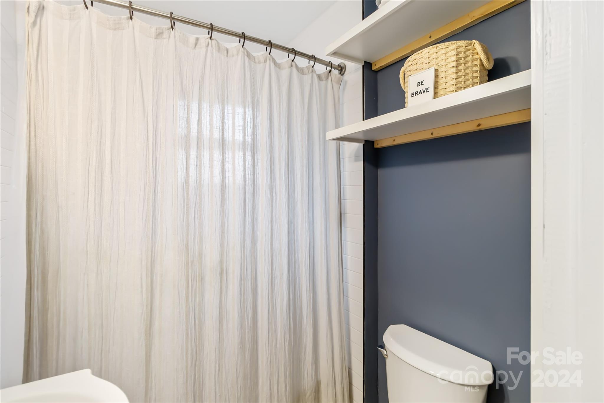 5500 Wilora Lake Road Charlotte, NC 28212 - Photo 21 of 32 a bathroom with a toilet a sink and a shower curtain