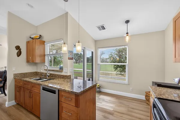 a kitchen with stainless steel appliances granite countertop a stove a microwave a sink and cabinets