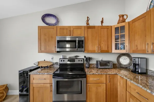 a kitchen with stainless steel appliances granite countertop a refrigerator and a stove top oven
