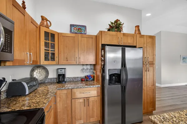 a kitchen with stainless steel appliances granite countertop a refrigerator a stove top oven a sink and dishwasher