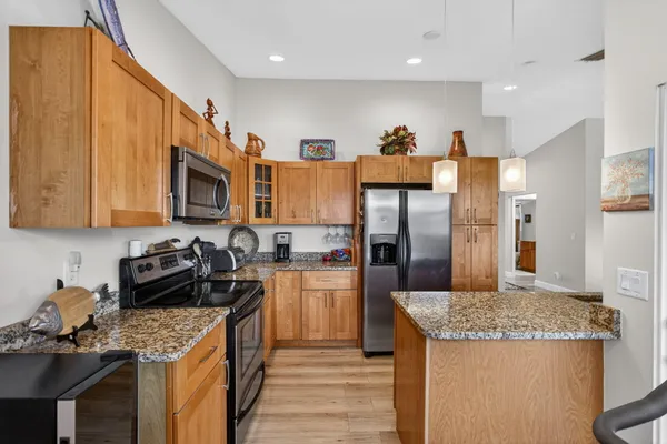 a kitchen with granite countertop a sink a counter top space stainless steel appliances and cabinets
