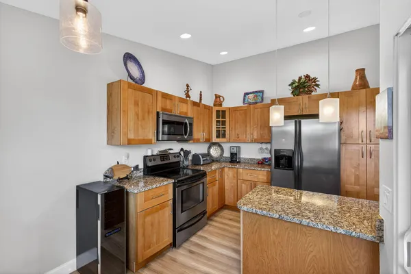 a kitchen with stainless steel appliances granite countertop a refrigerator and a sink