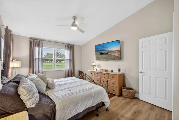 a bedroom with a bed and a flat tv screen on dresser