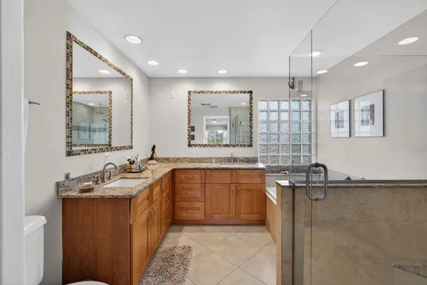 a spacious bathroom with a granite countertop sink mirror and shower