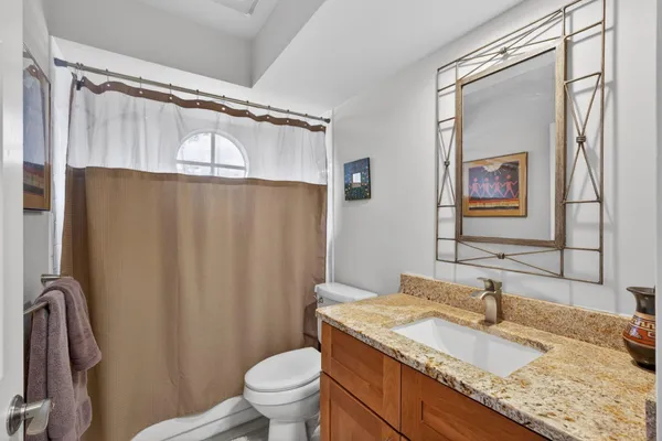 a bathroom with a granite countertop sink toilet and shower