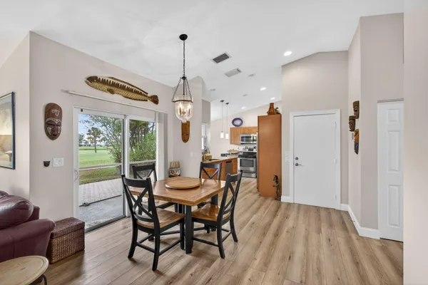 a dining room with furniture a chandelier and wooden floor