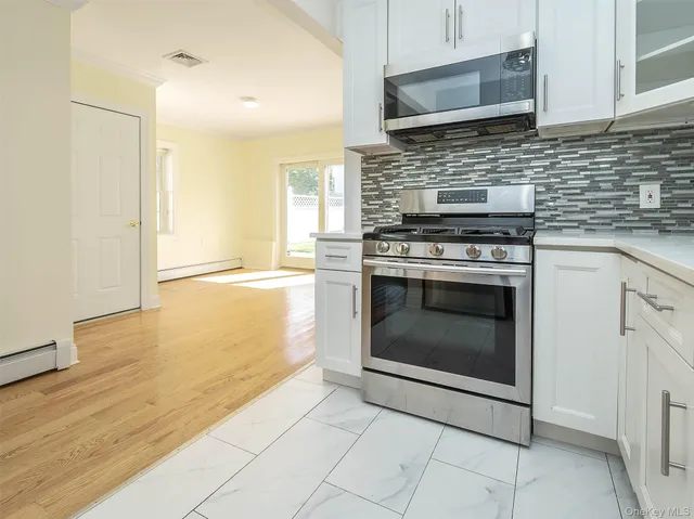 a kitchen with granite countertop a stove top oven microwave and cabinets