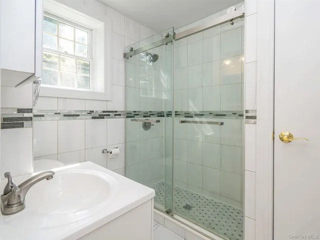 a bathroom with a sink a shower and a mirror