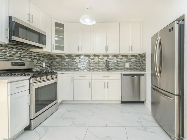 a kitchen with white cabinets stainless steel appliances and a sink