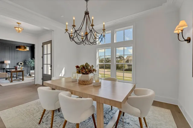 a kitchen with stainless steel appliances kitchen island granite countertop a dining table chairs and white cabinets