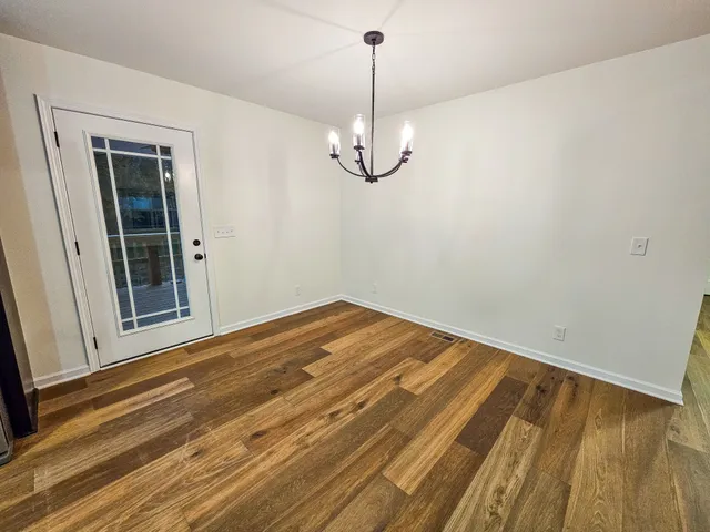a view of a room with wooden floor and white walls