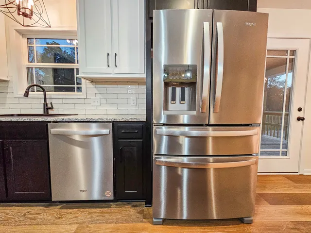 a metallic refrigerator freezer sitting inside of a kitchen