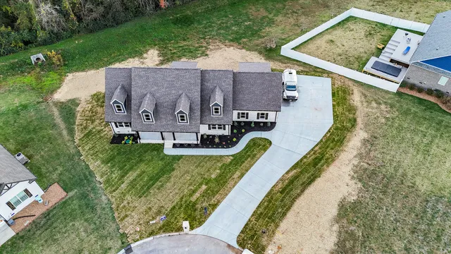 an aerial view of a house with swimming pool and a yard
