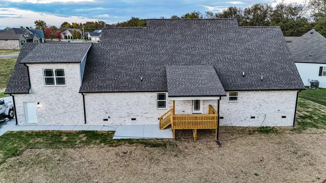 an aerial view of a house with a yard and wooden fence