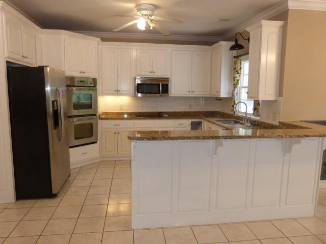 1650 Locklin Cemetery Road Monroe, GA 30655 - Photo 50 of 72 a kitchen with stainless steel appliances granite countertop a refrigerator a stove a sink and white cabinets